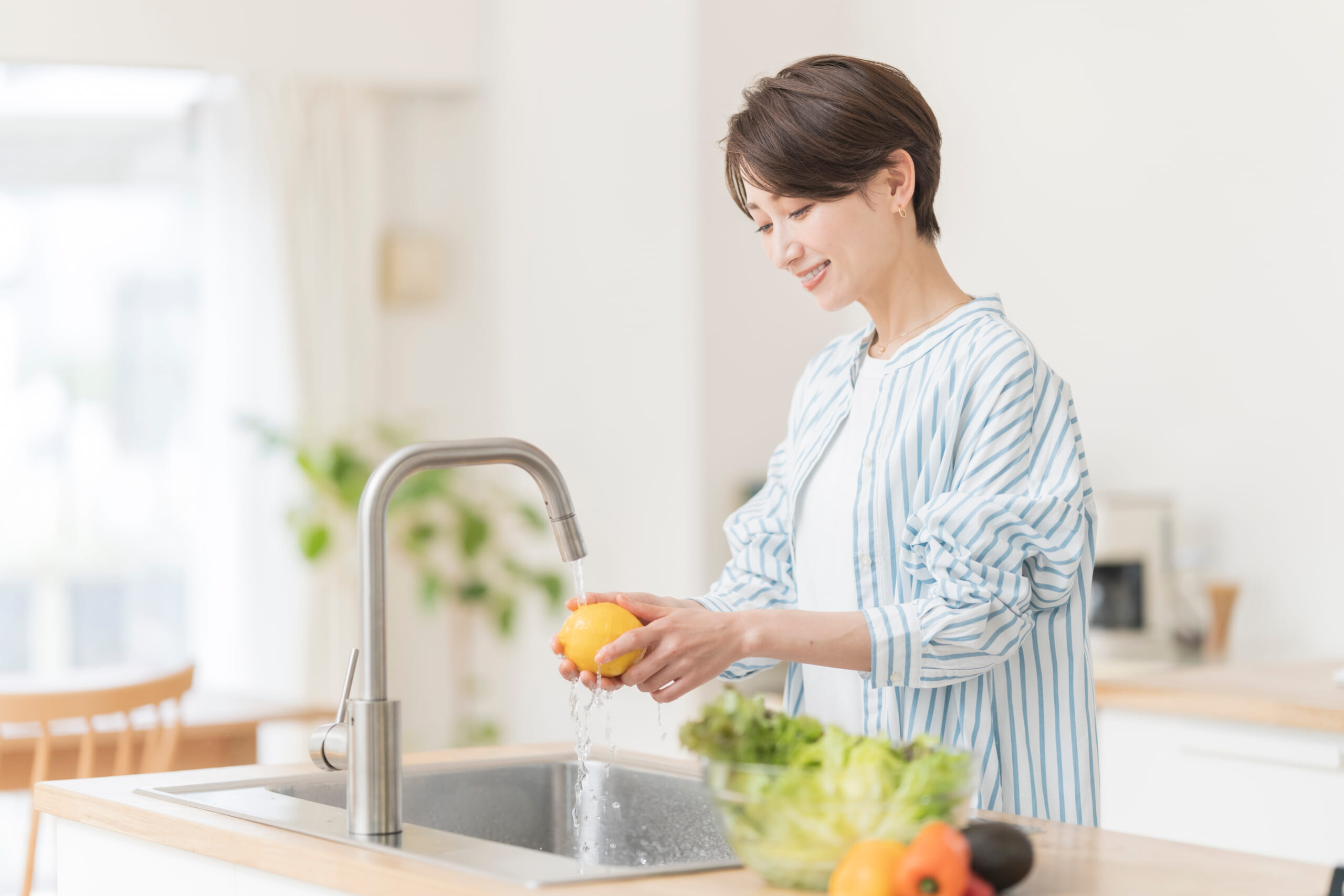 キッチンで笑顔で料理をしている主婦